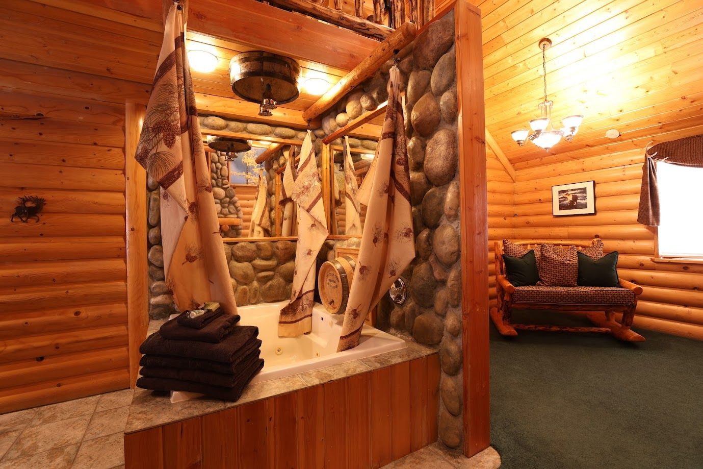 A log cabin bathroom with a jacuzzi tub and a couch.