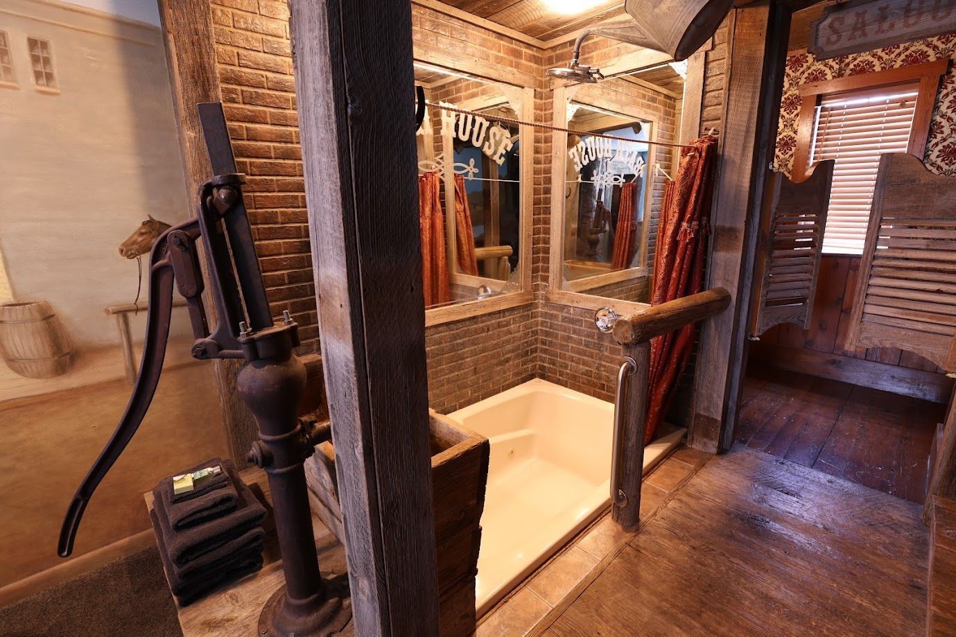 A bathroom with a bathtub , mirrors and a water pump.