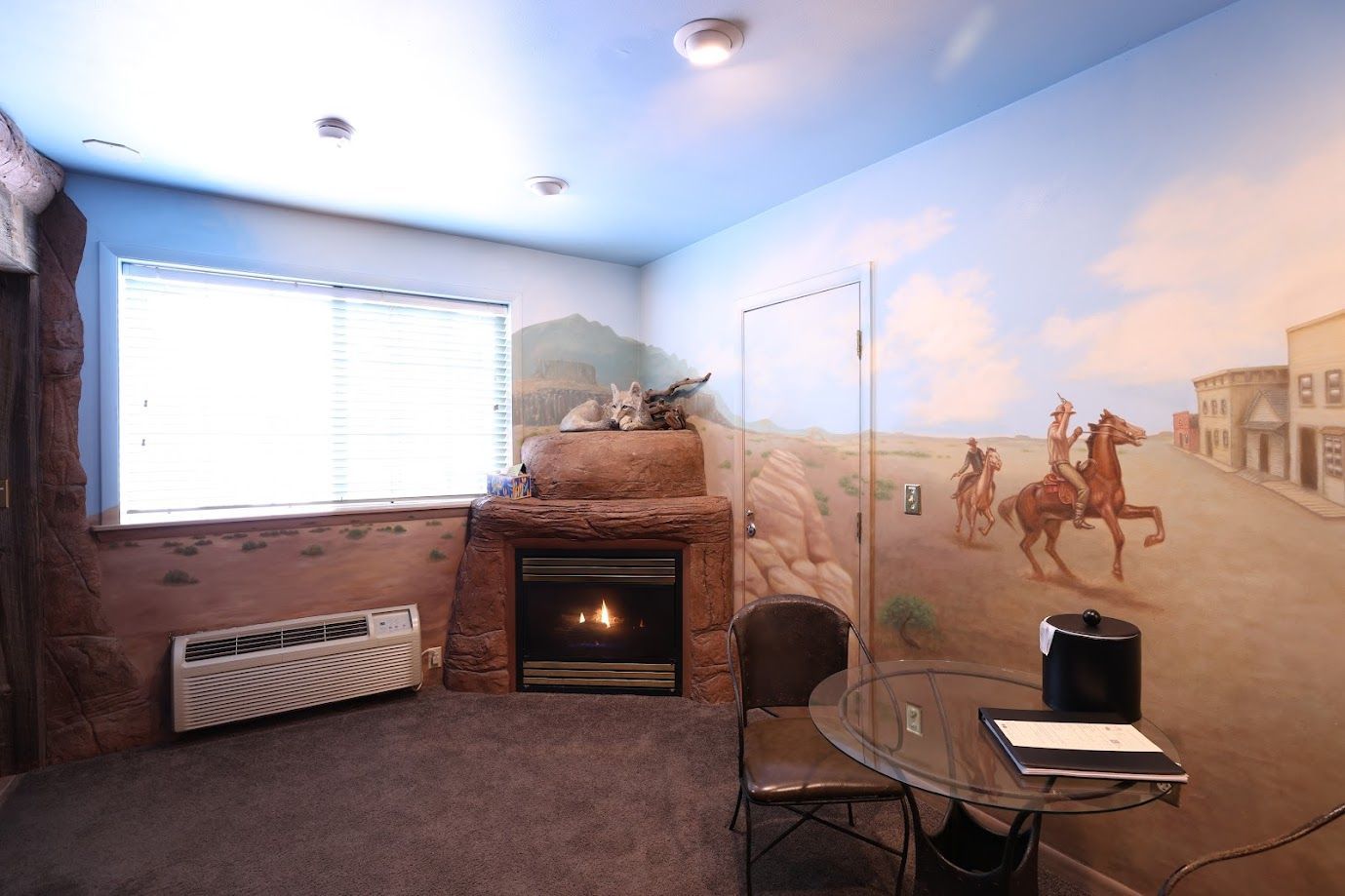 A living room with a fireplace and a painting on the wall.