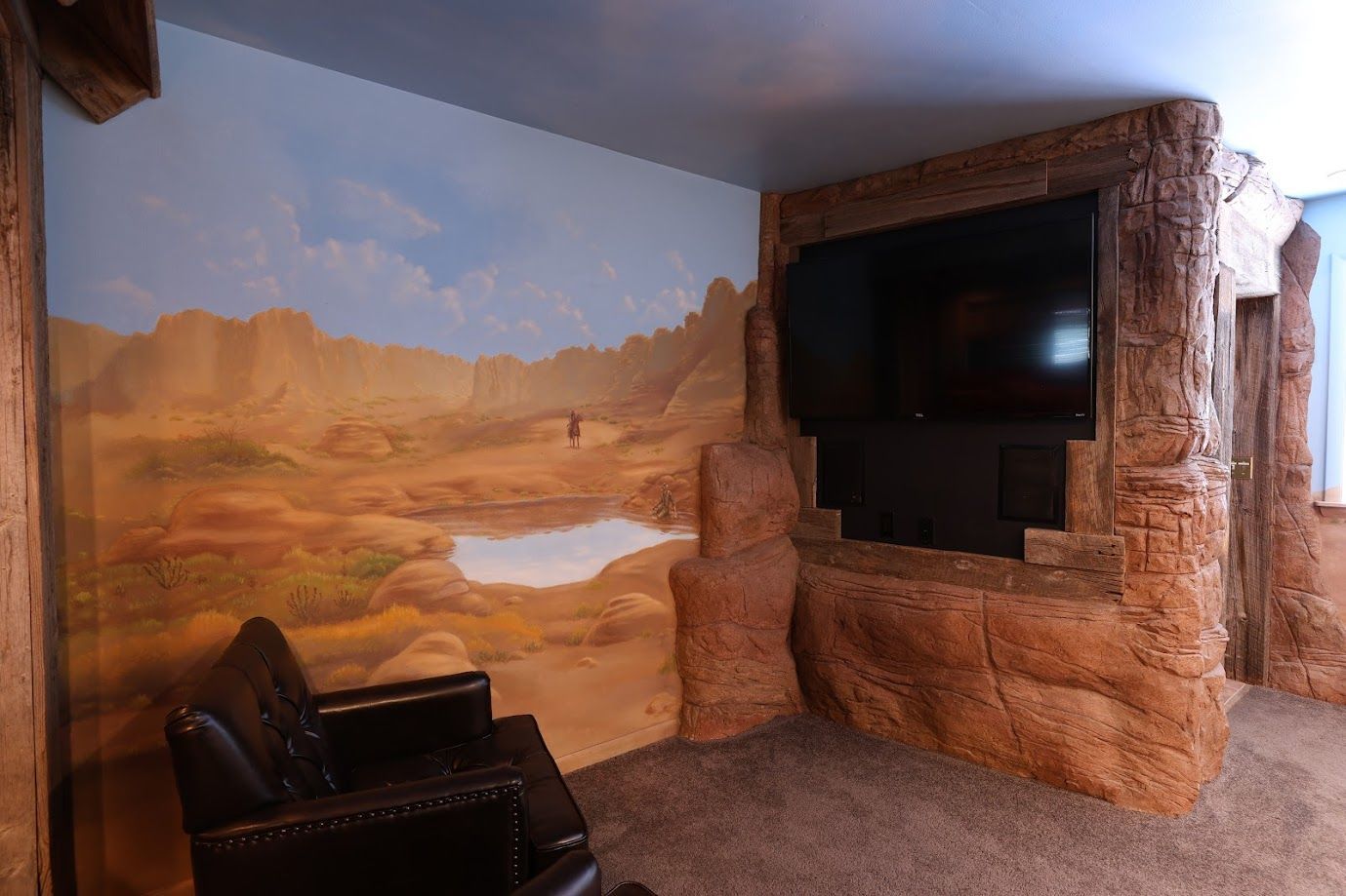 A living room with a painting on the wall and a flat screen tv.