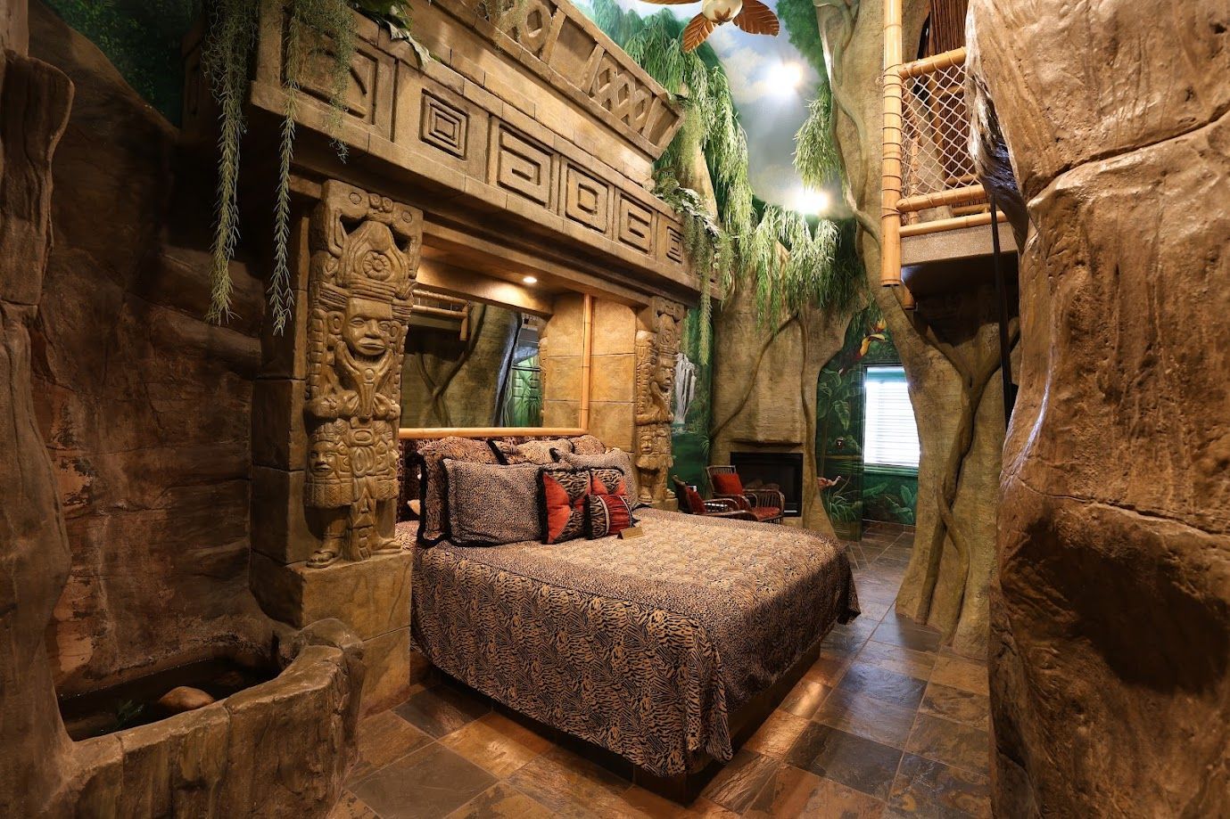 A bedroom with a bed and a fireplace in a cave.