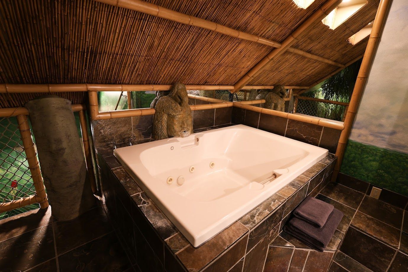 A jacuzzi tub in a bathroom with a bamboo roof