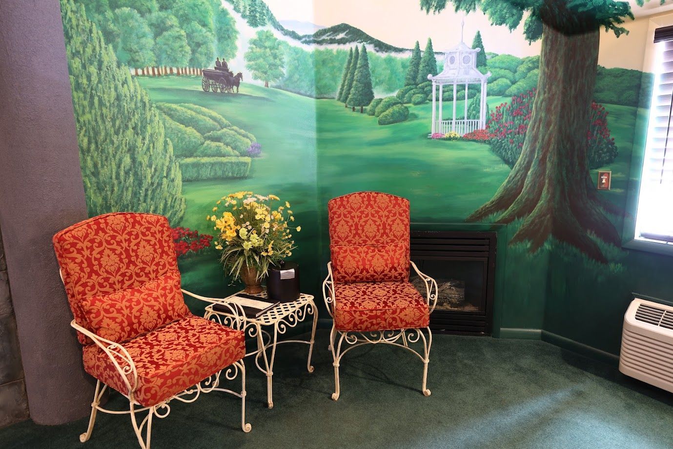 Two chairs and a table in a room with a painting on the wall