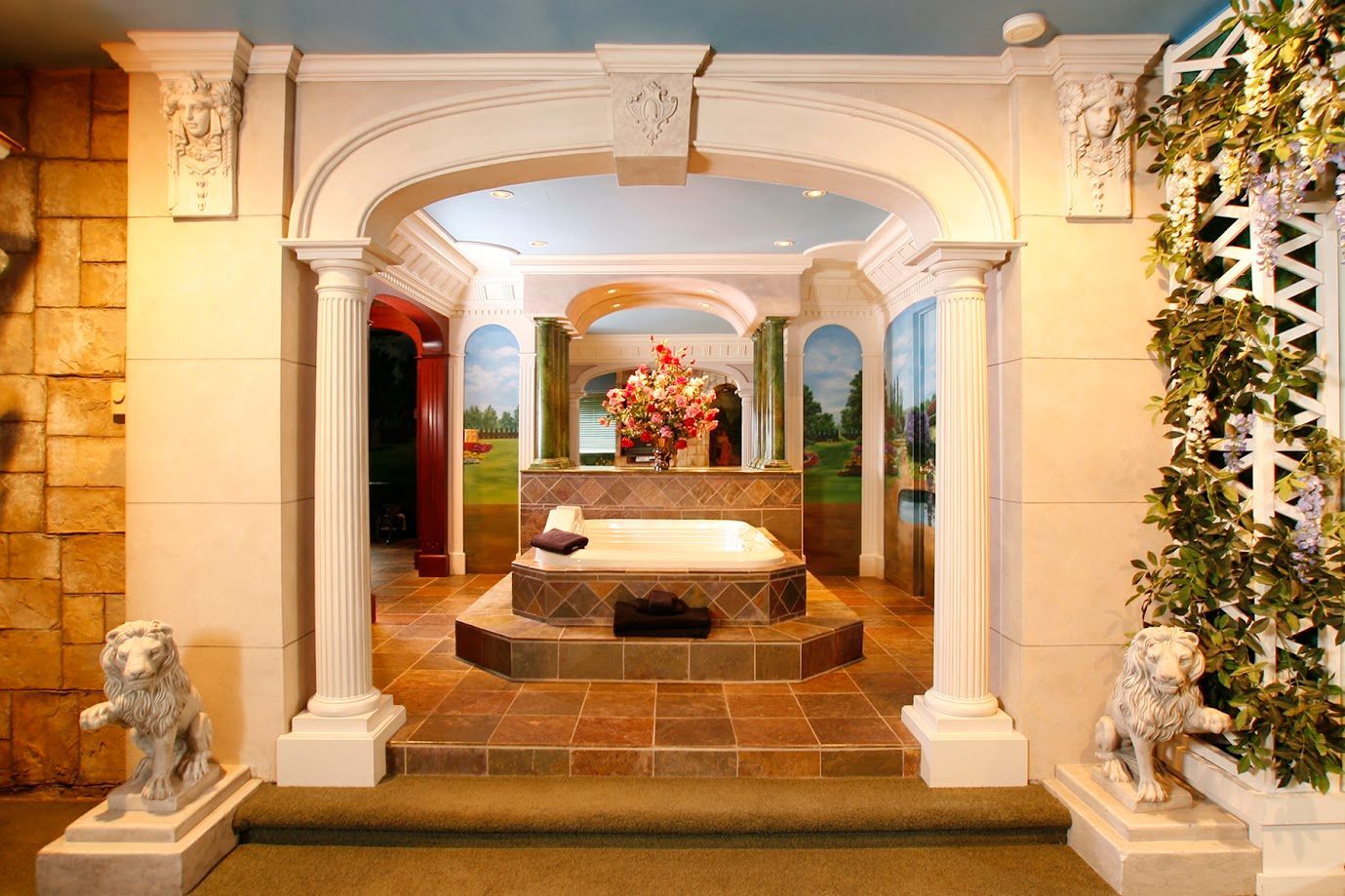 A bathroom with columns and a jacuzzi tub