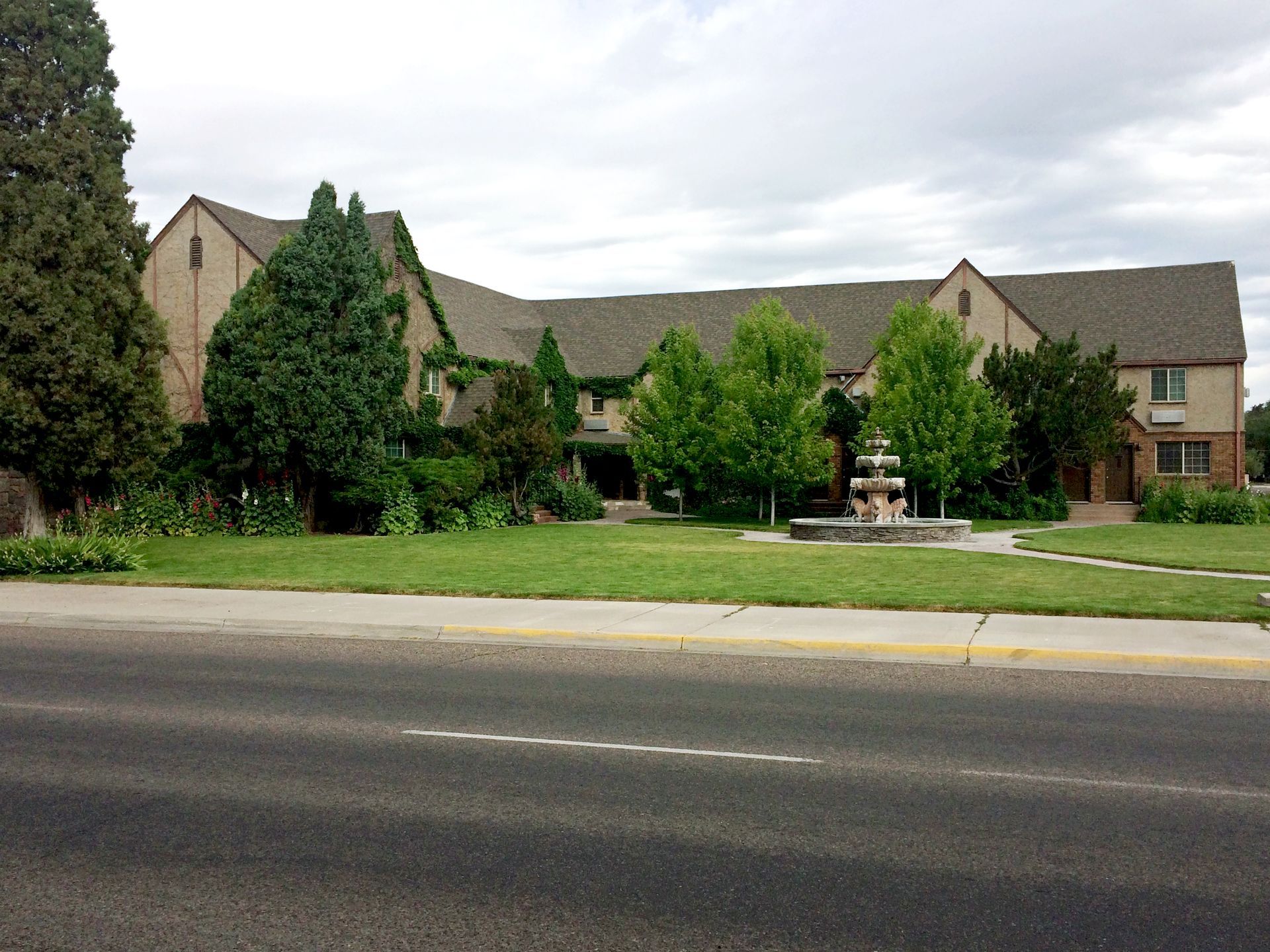 A large house with a fountain in front of it