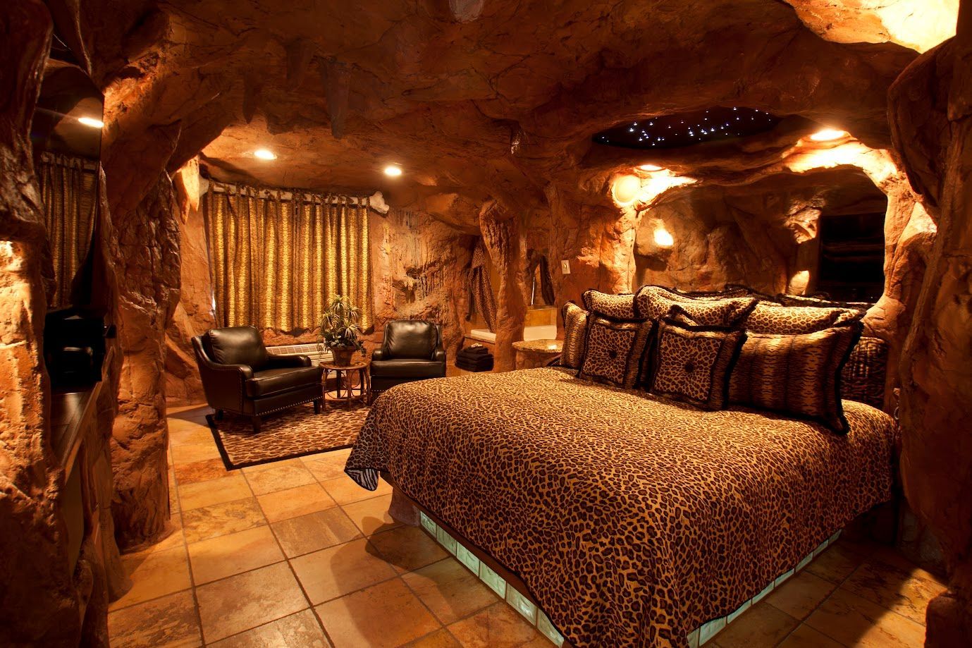 A bedroom in a cave with a leopard print bed