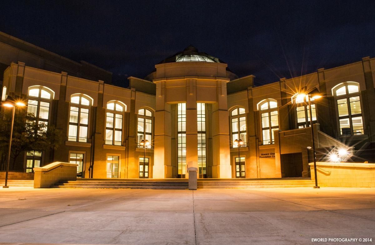 A large building with lots of windows is lit up at night