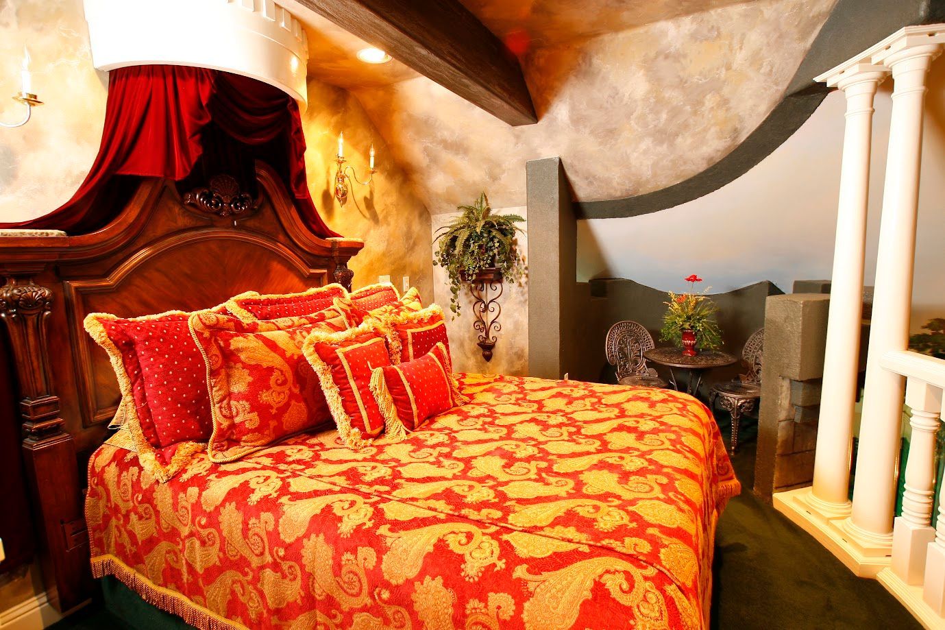 A bed with a red and gold blanket in a hotel room