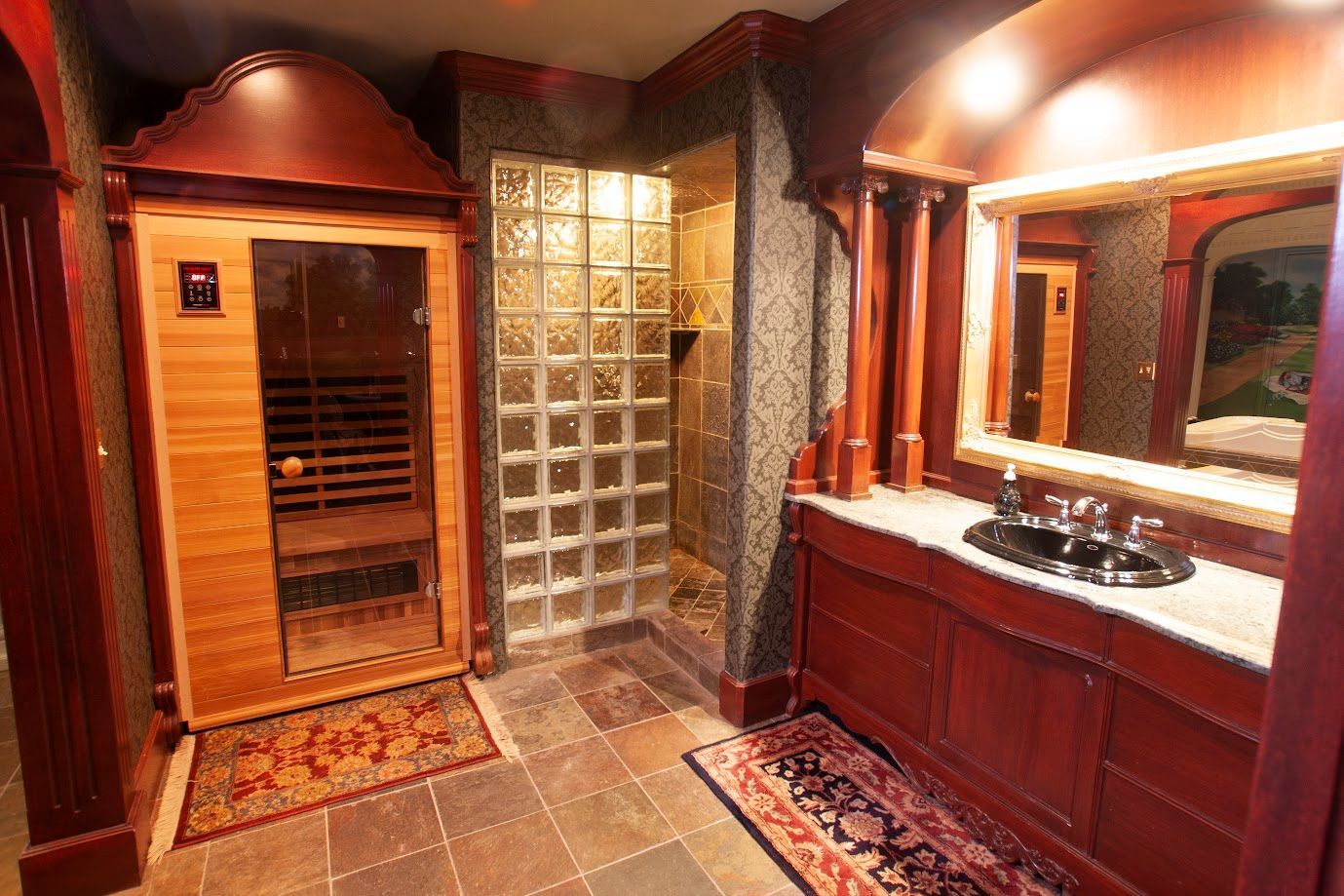 A bathroom with a sauna , sink and mirror.