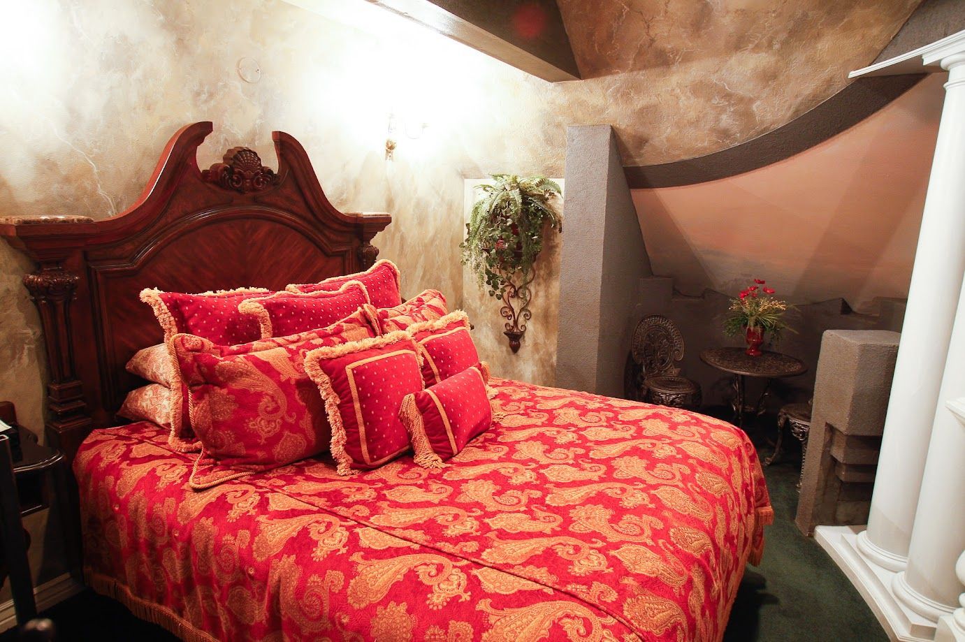 A bed with a red blanket and pillows in a bedroom