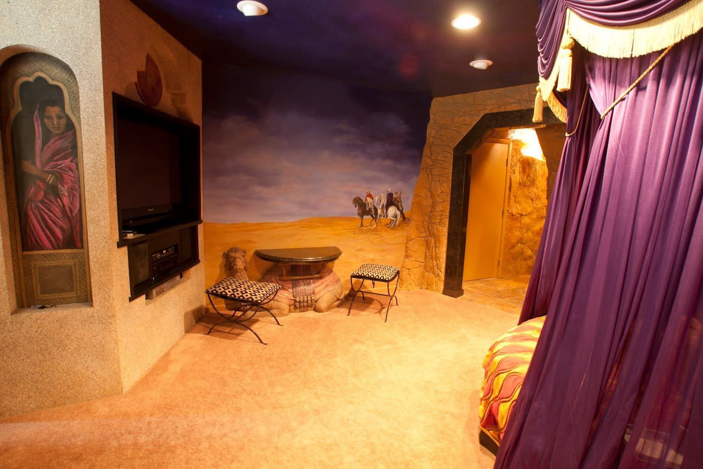 A room with a purple canopy and a painting on the wall