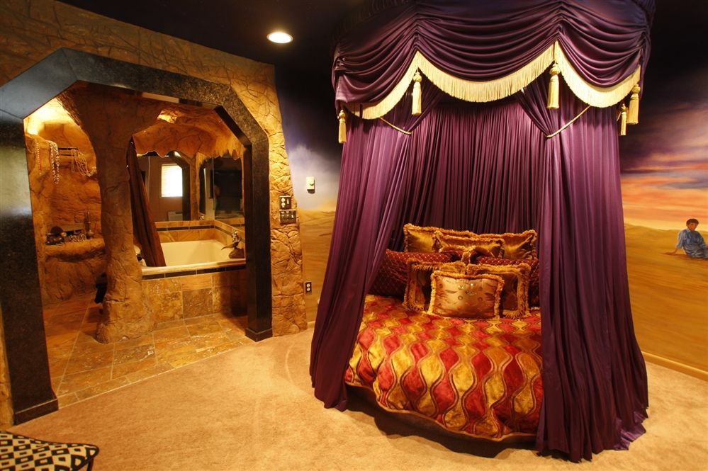 A bedroom with a canopy bed and a bathtub