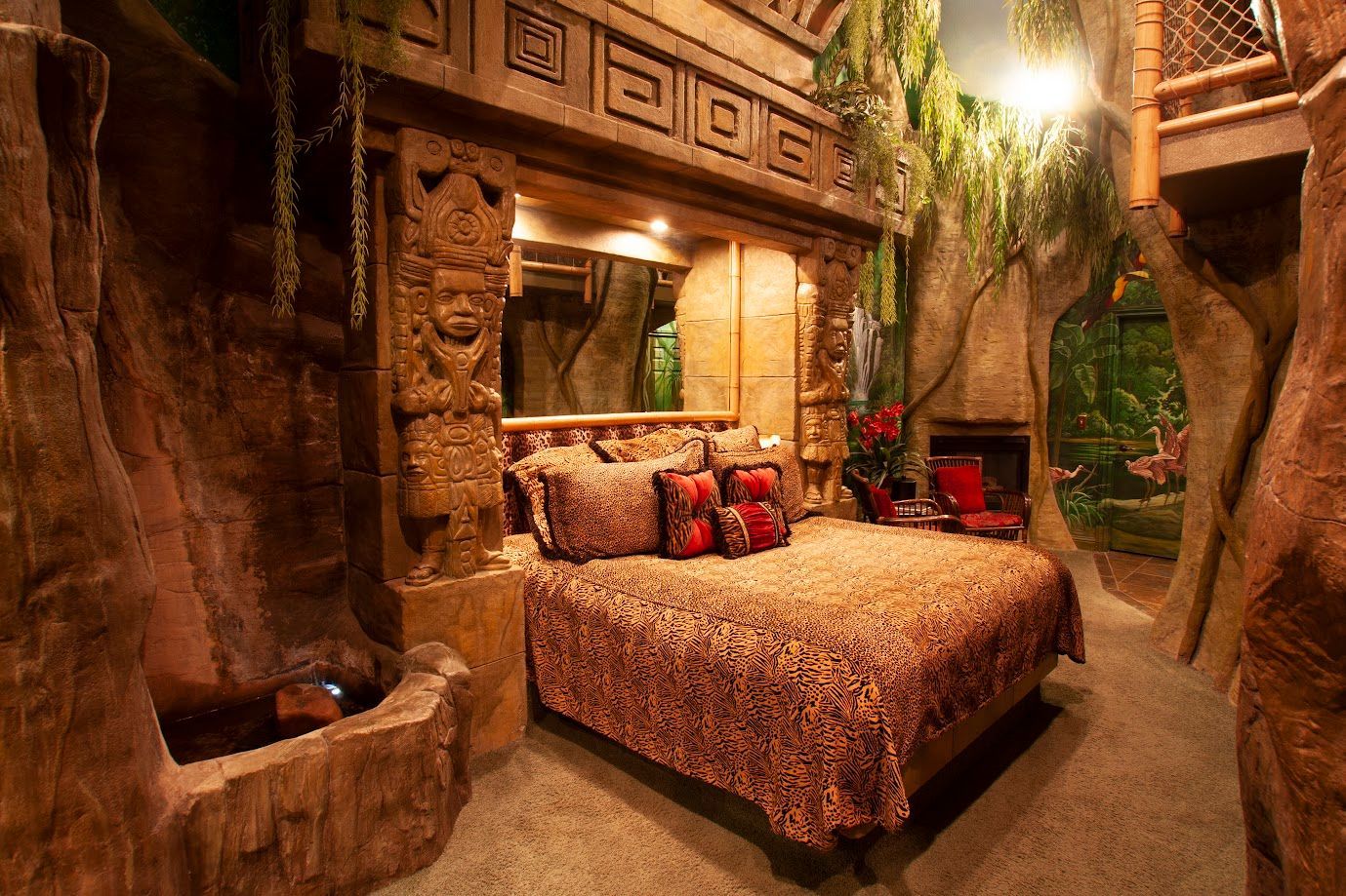 A bedroom with a bed and a fireplace in a cave.