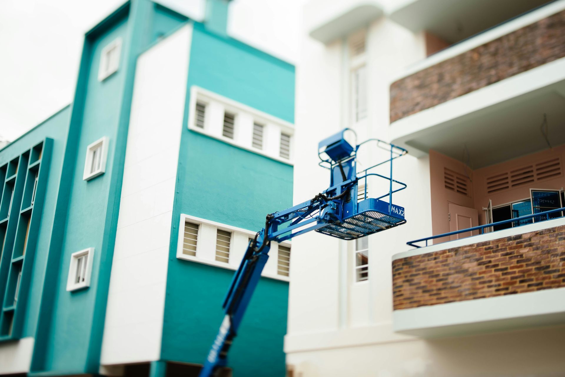 A corner of a building featuring vertical orange and red panels meeting a dark blue, wavy patterned metal facade.