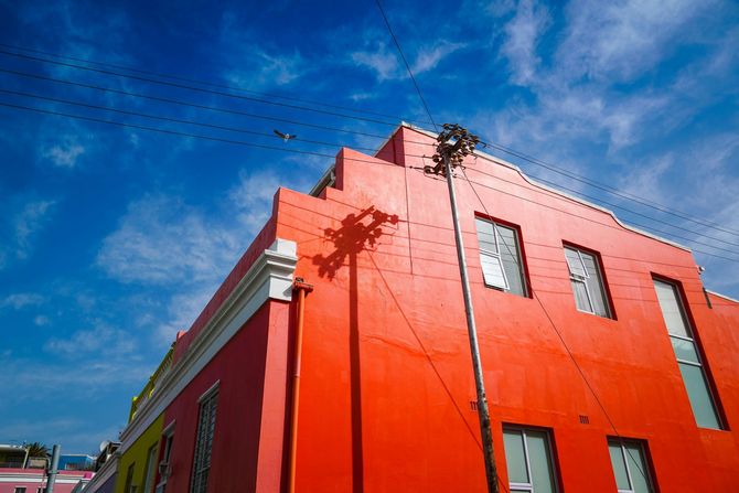 a semi-detached home with one side painted with blue and the other red