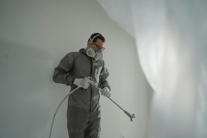 a guy wearing protective mask that is ready to paint indoor