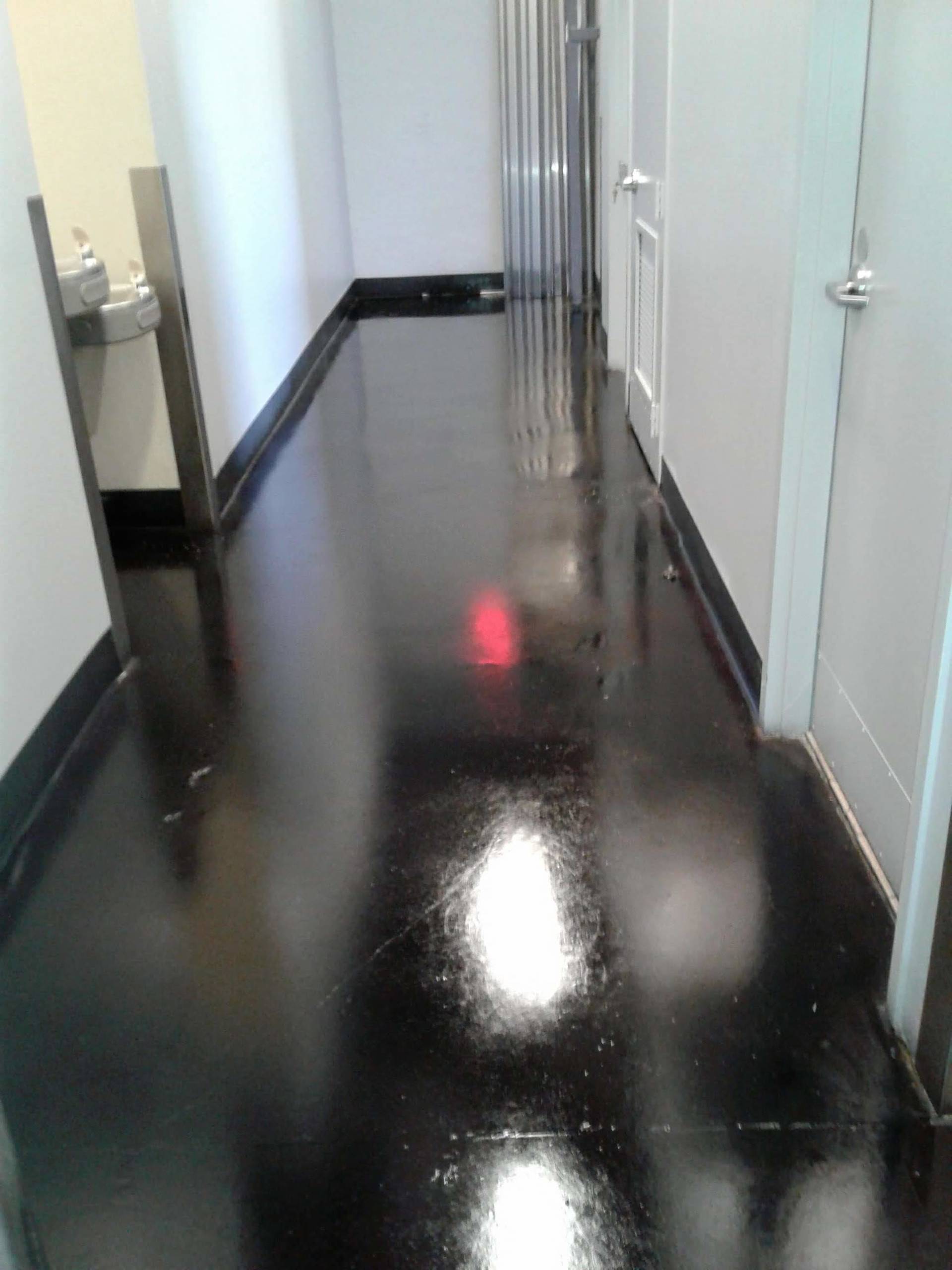 A hallway with a black floor and white walls