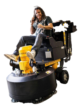 A man is sitting on a machine talking on a cell phone.
