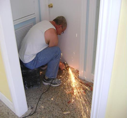 A man is using a grinder to cut a piece of metal