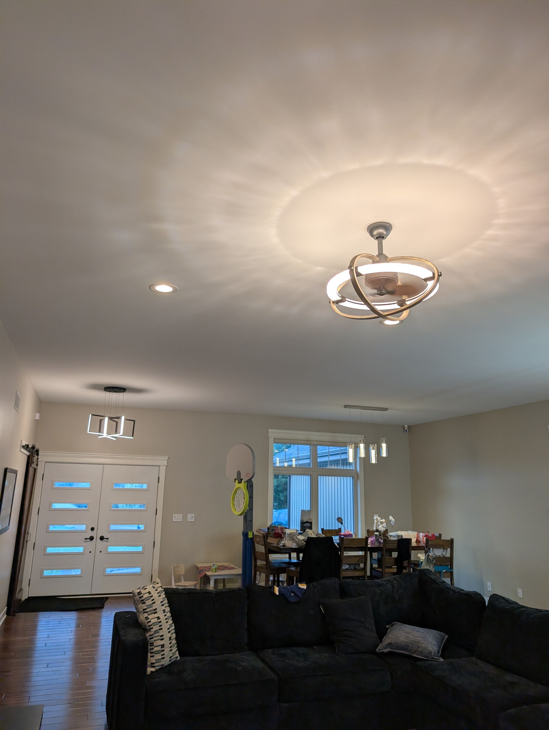 Interior view of a living space, with a ceiling fan and a dining table visible.