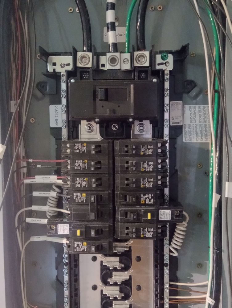 Electrical panel with various circuit breakers and wiring.