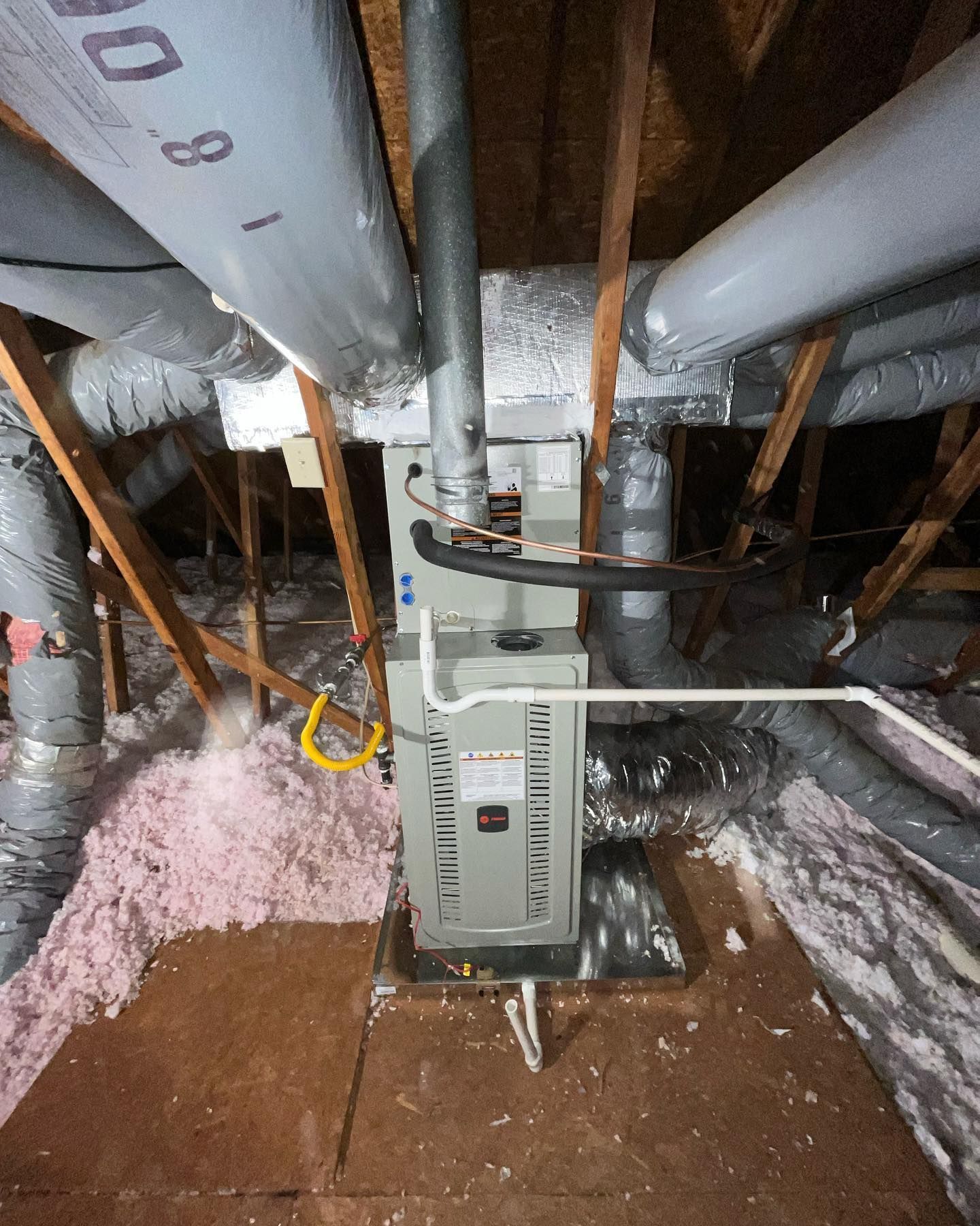 An air conditioner is installed in the attic of a house.