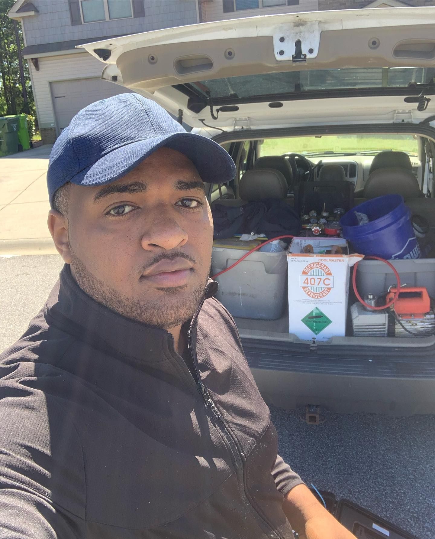 A man in a baseball cap is sitting in the back of a car.