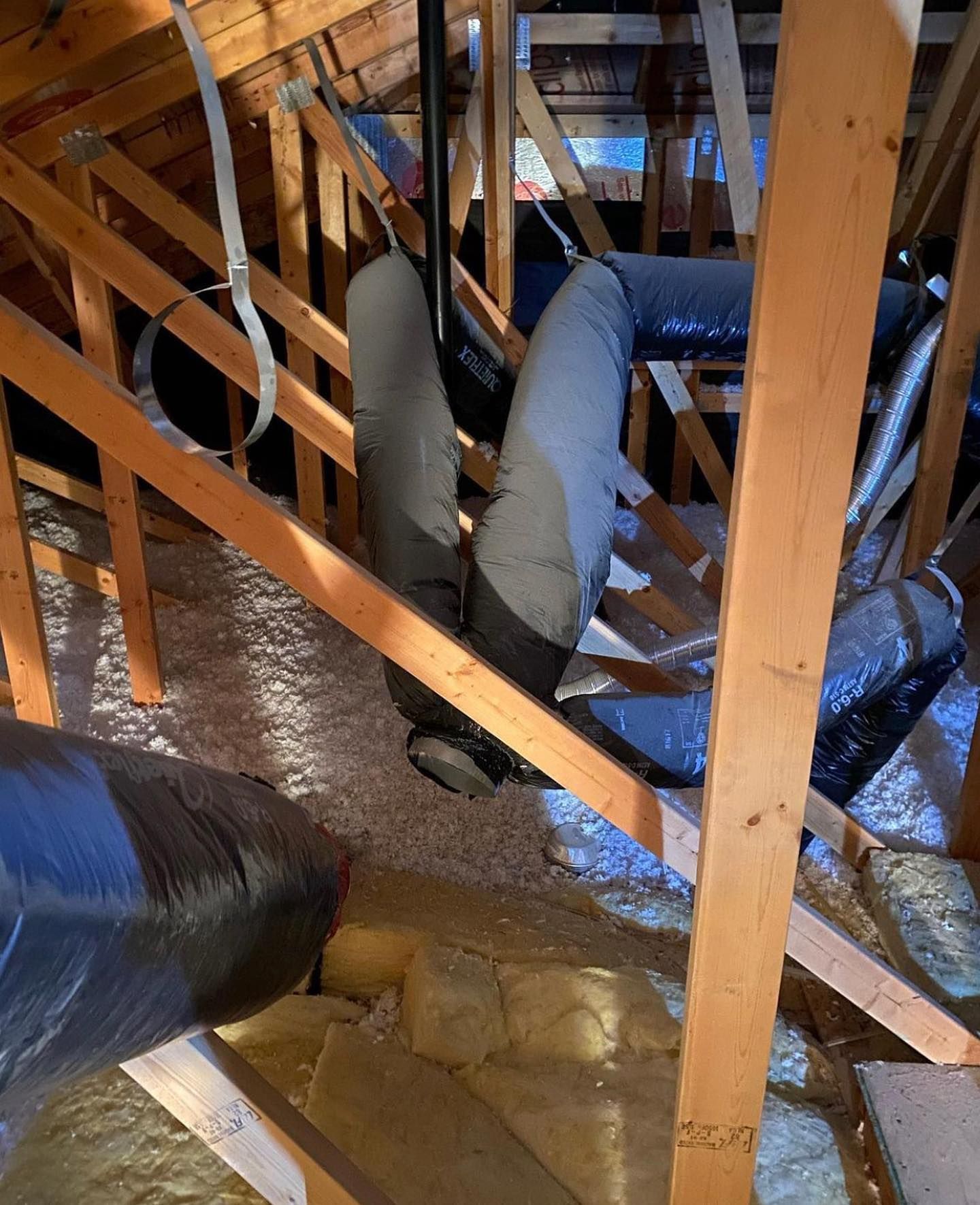 A bunch of bags of insulation are hanging from the ceiling of a building