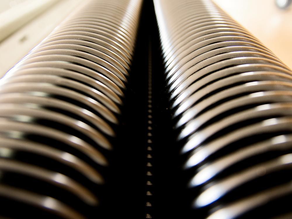 A close-up view of two rows of stacked, metallic circular discs separated by a dark, vertical gap.