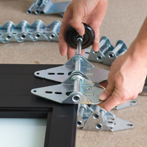 Hands assembling a metal bracket with a screwdriver on a black-framed device panel