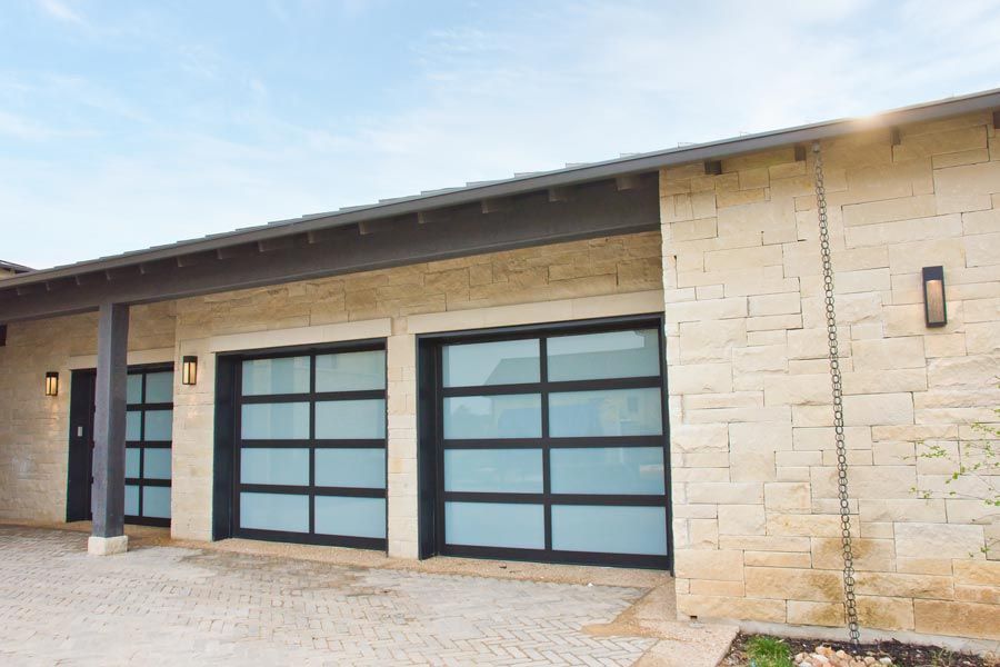Modern house exterior with two frosted glass garage doors and stone walls