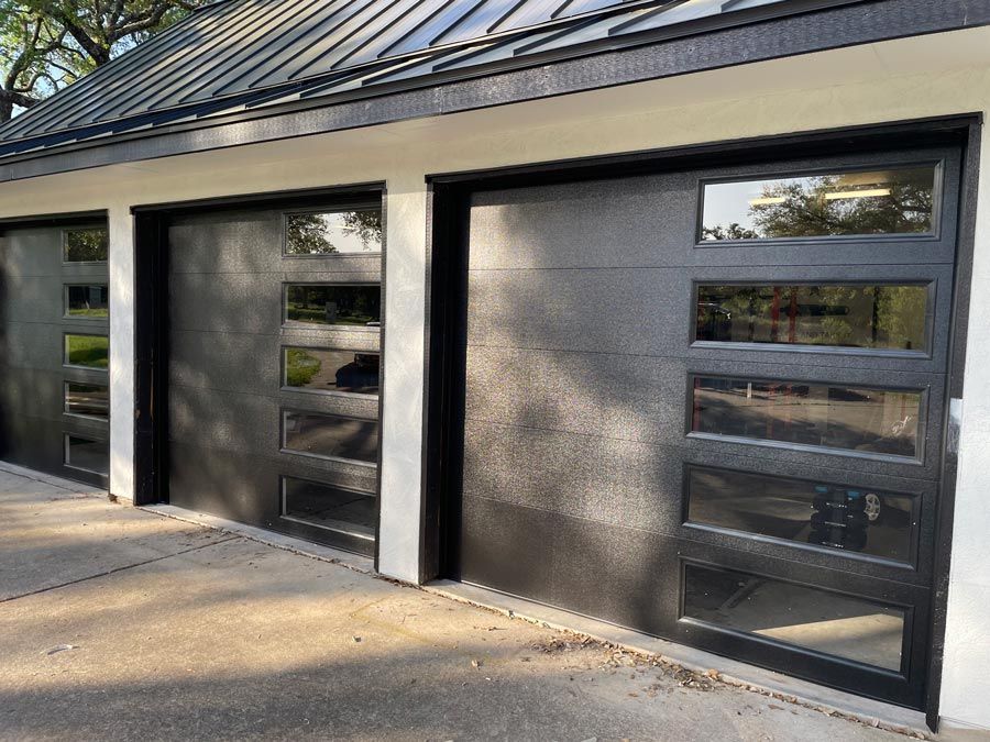 Modern building exterior with two dark garage-style doors and narrow vertical windows