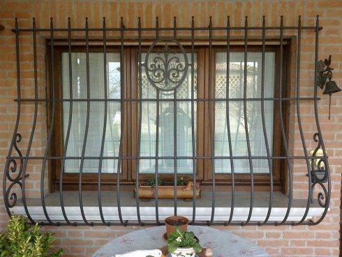 Sbarre fisse in ferro davanti una finestra di legno