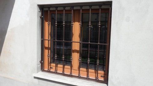 Finestra di legno con inferriata decorativa