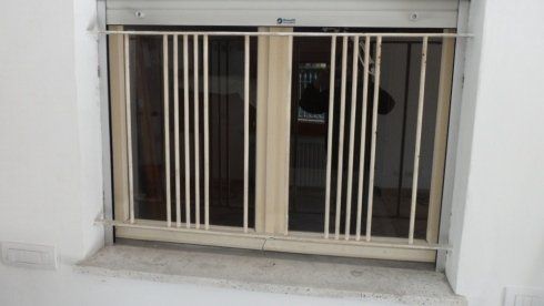 Finestra a doppia anta con inferriata bianca