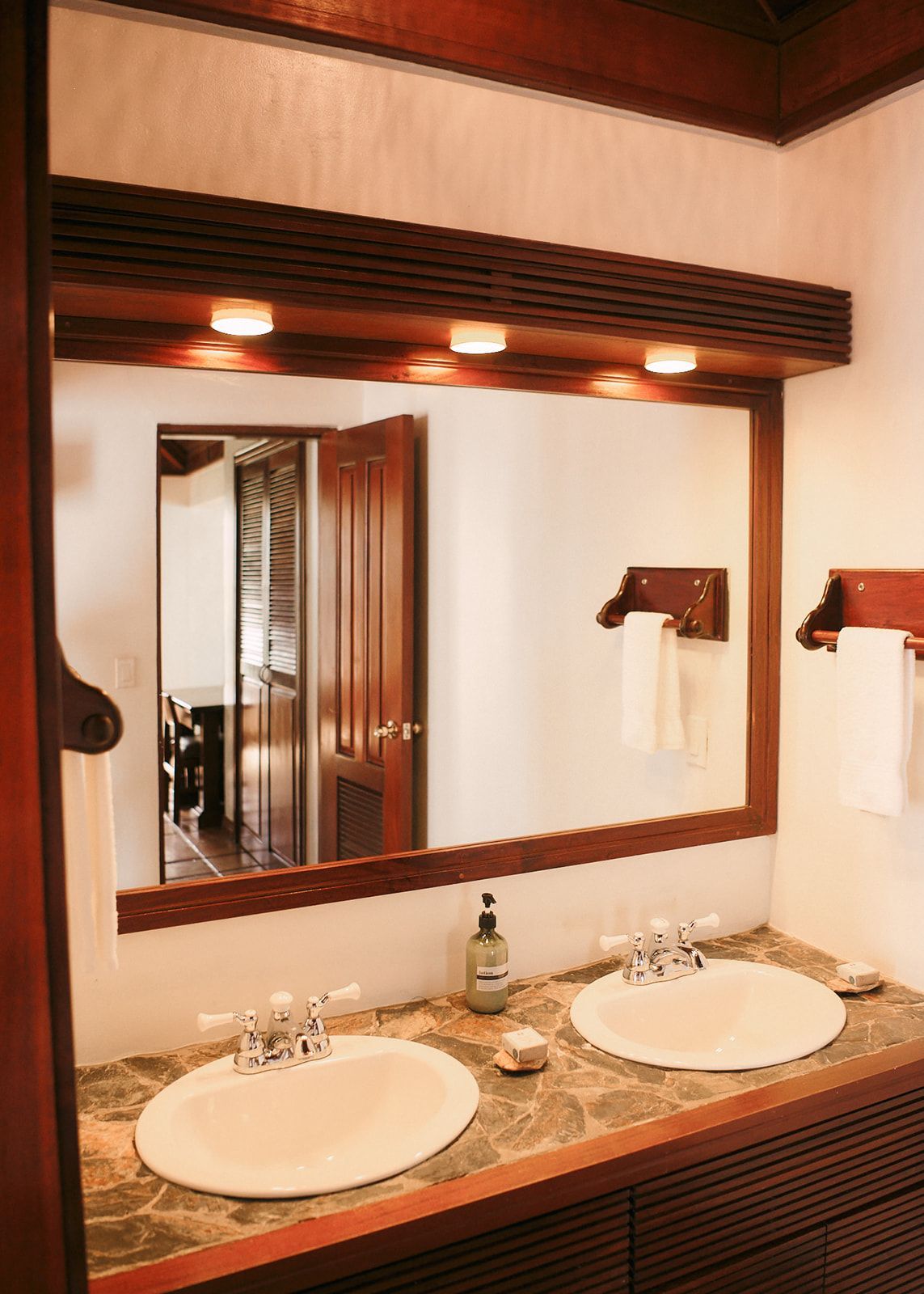 A bathroom with two sinks and a large mirror.