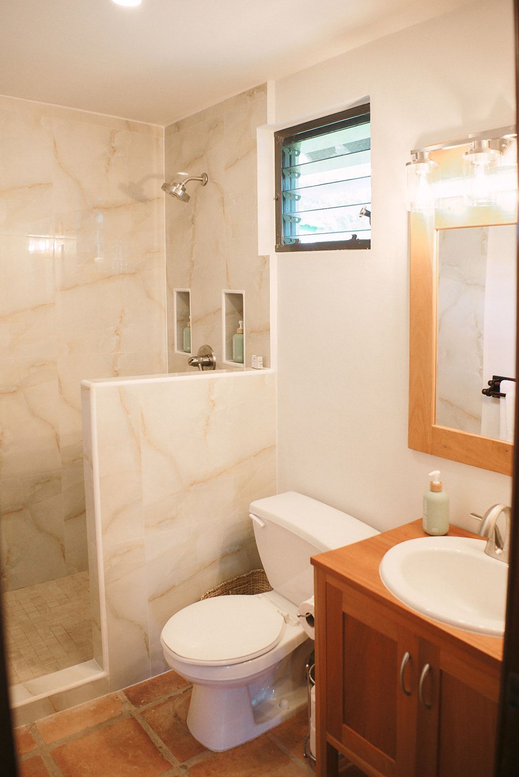 A bathroom with a toilet , sink and shower.