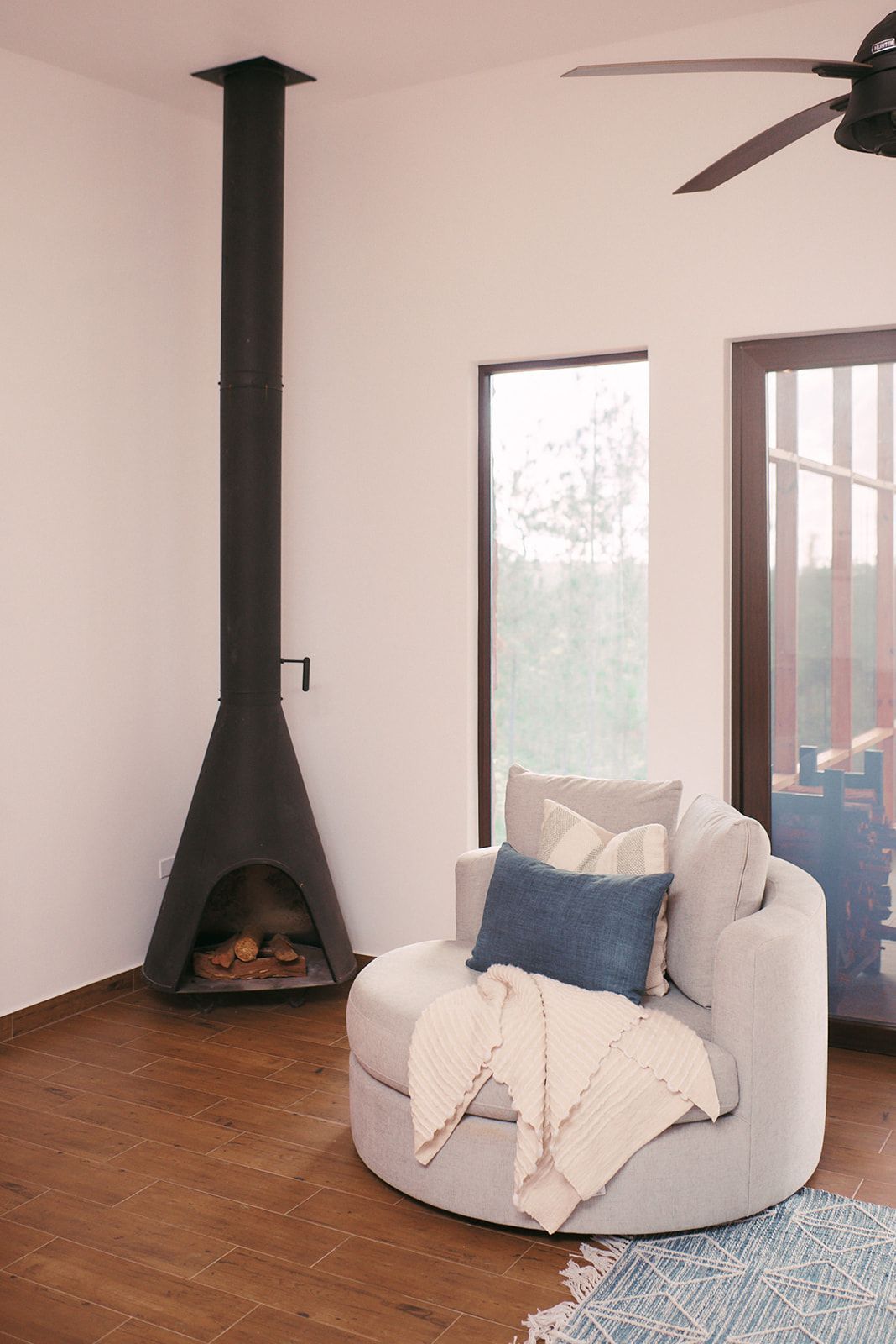 A relaxing corner in the Valley View Villas with a fireplace and a plush, round chair, creating a warm, inviting atmosphere.