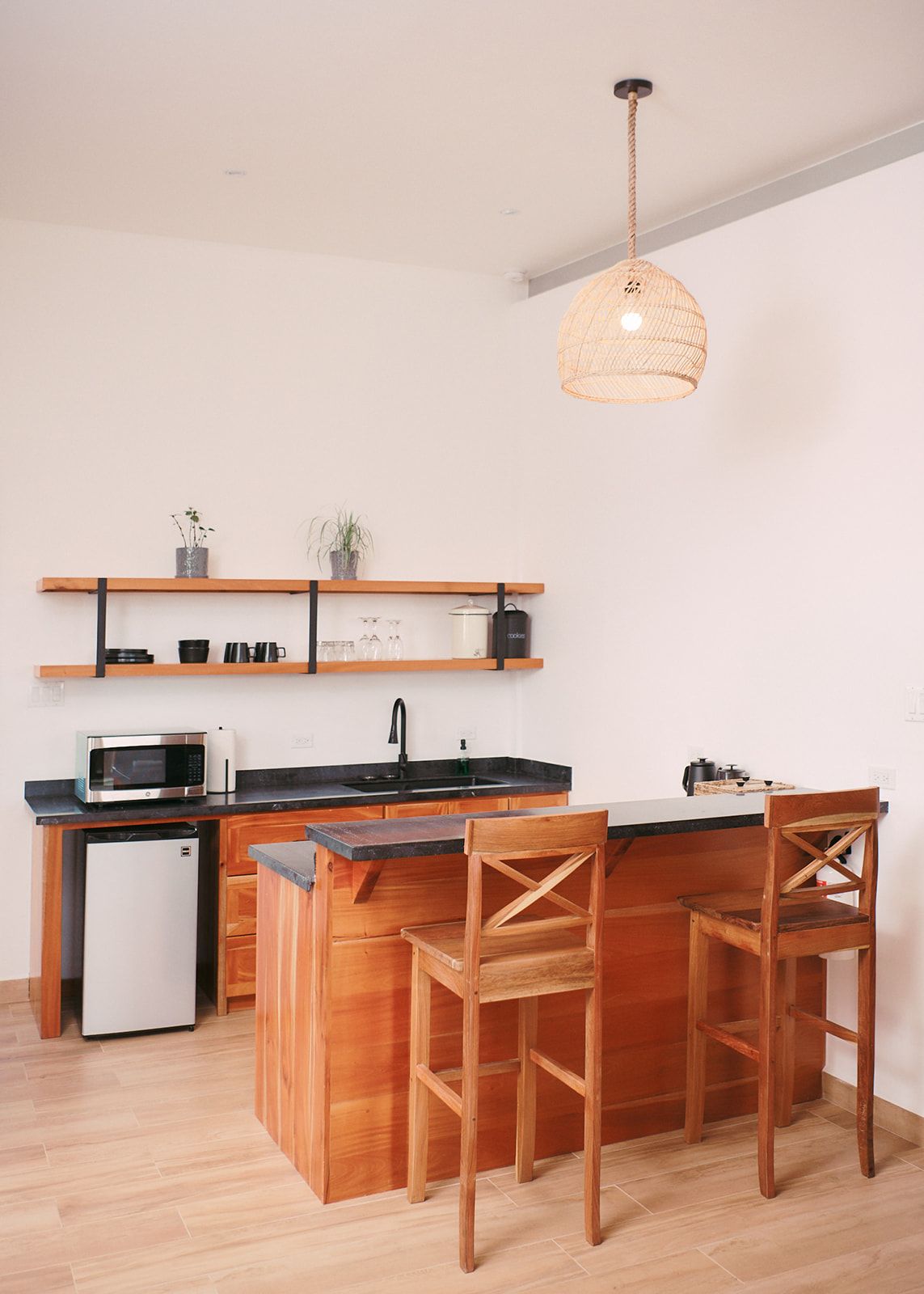Chic kitchenette with wooden cabinets and modern appliances, perfect for an intimate, luxurious stay.