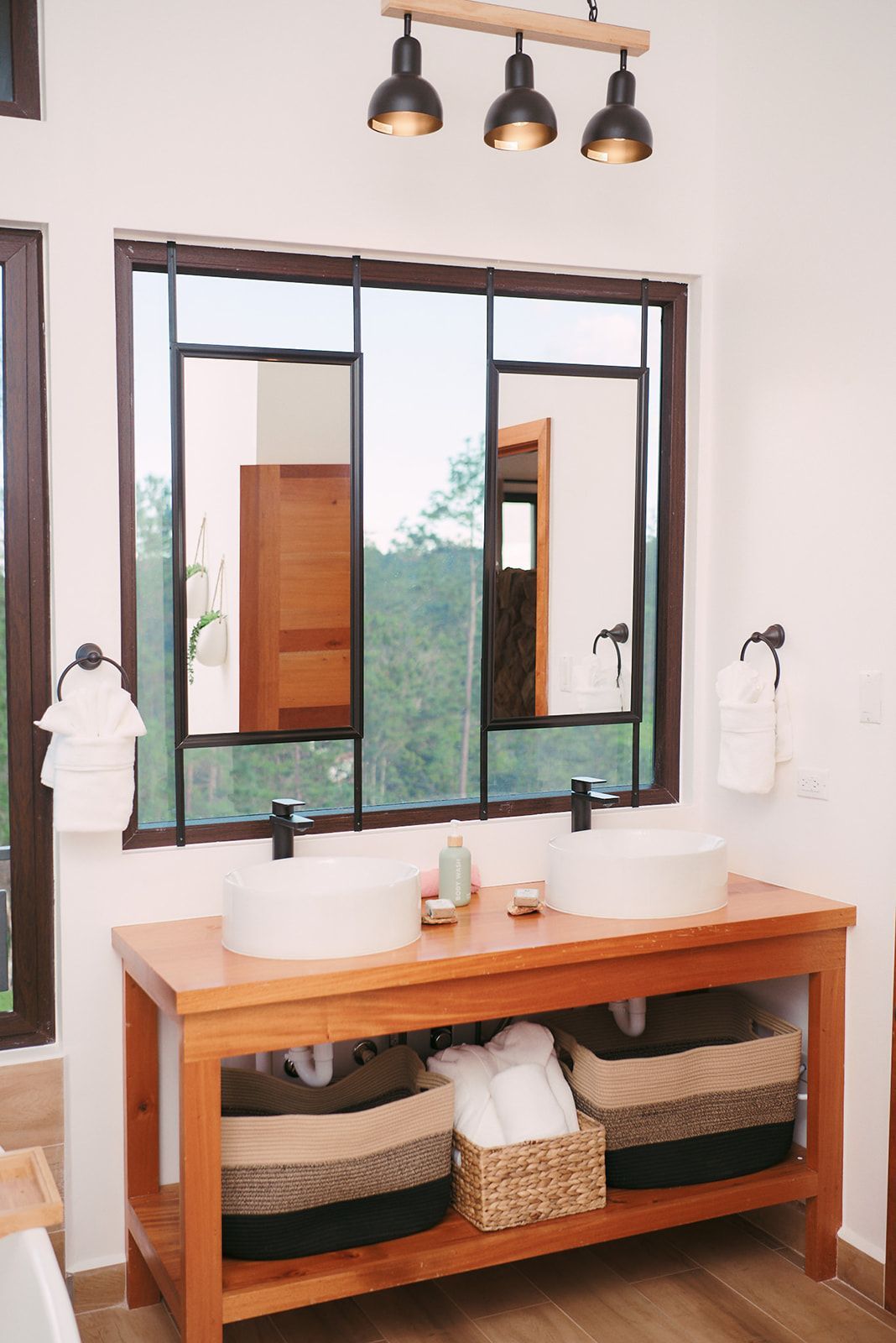 Elegant double sink vanity in Fire Tower's bathroom, surrounded by large windows with lush forest views.