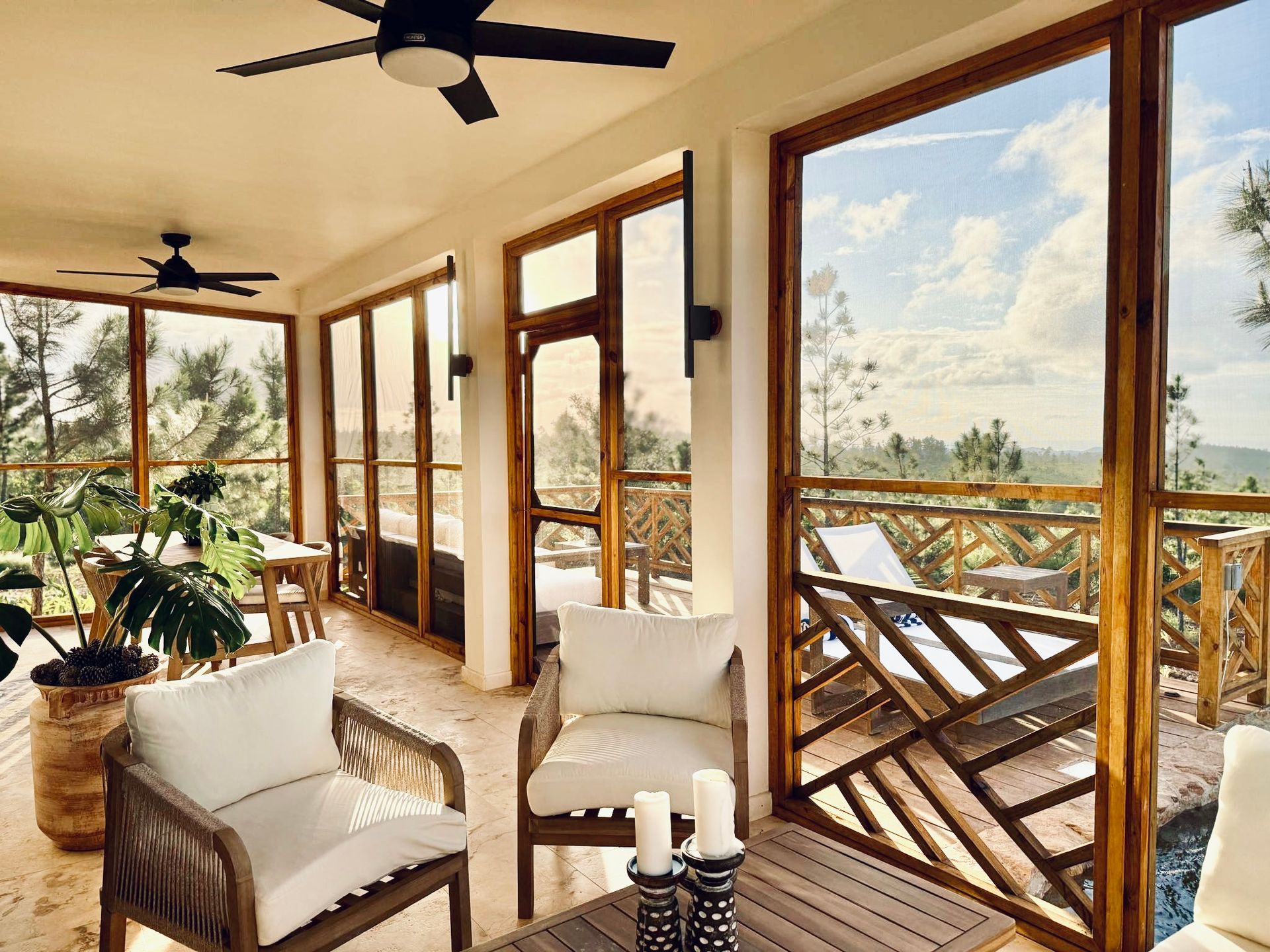 A living room with a lot of windows and a ceiling fan