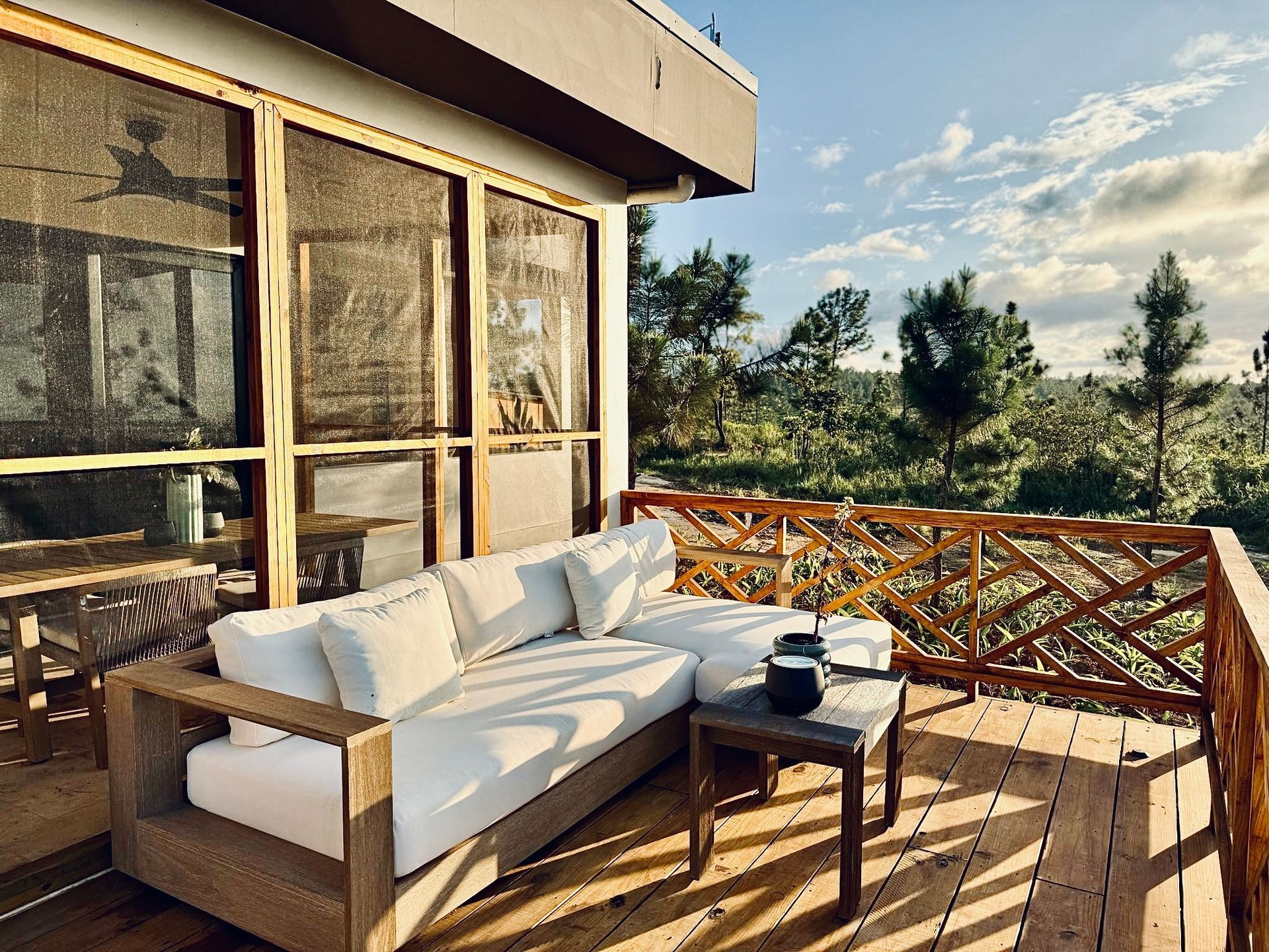 A wooden deck with a couch and a table on it.