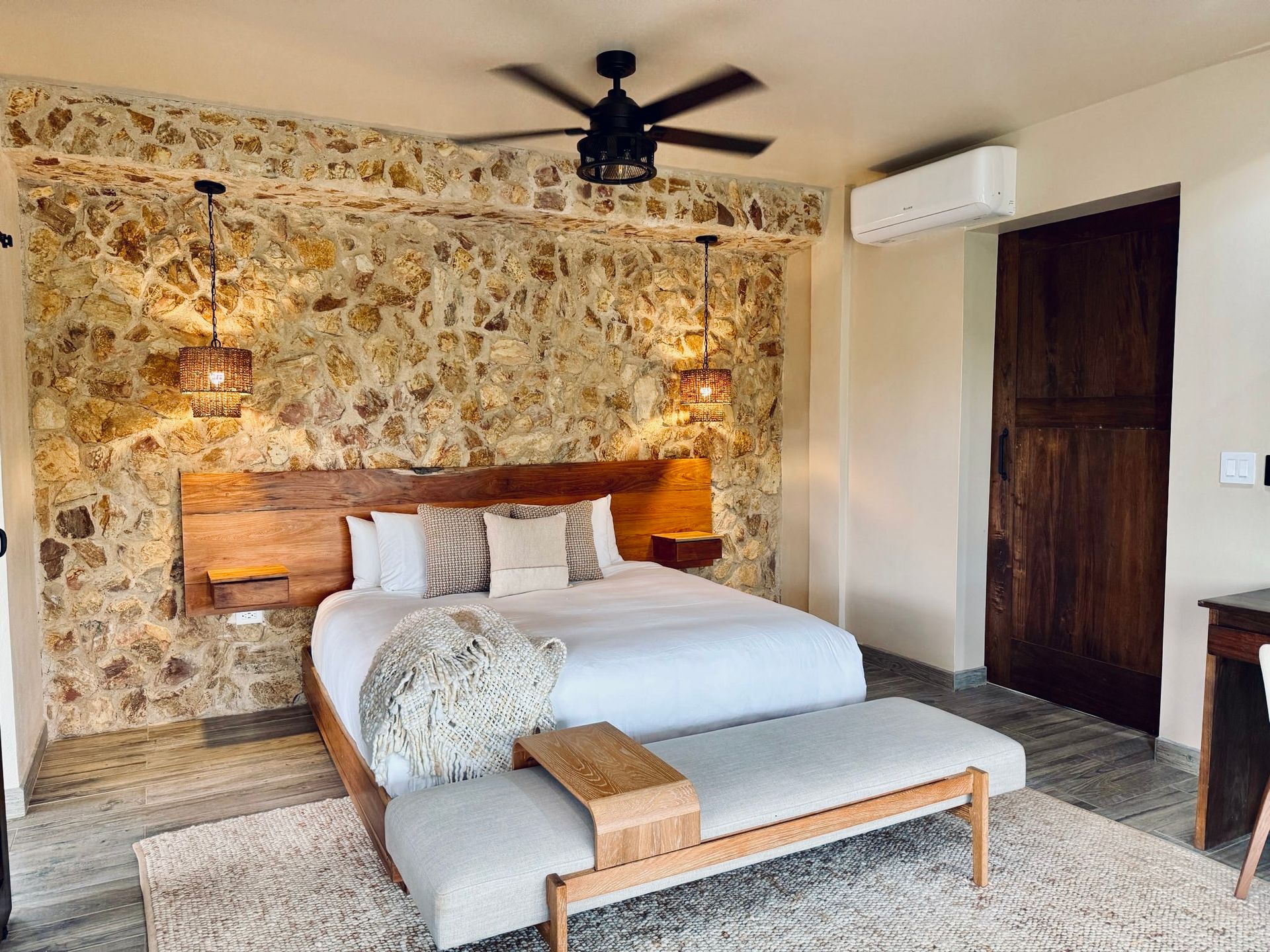 A bedroom with a king size bed and a ceiling fan.