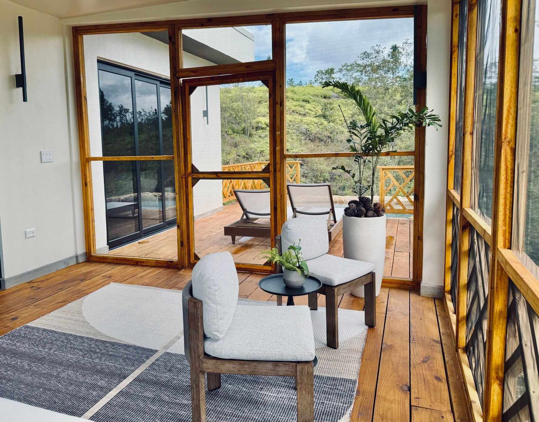 A living room with a lot of windows and chairs