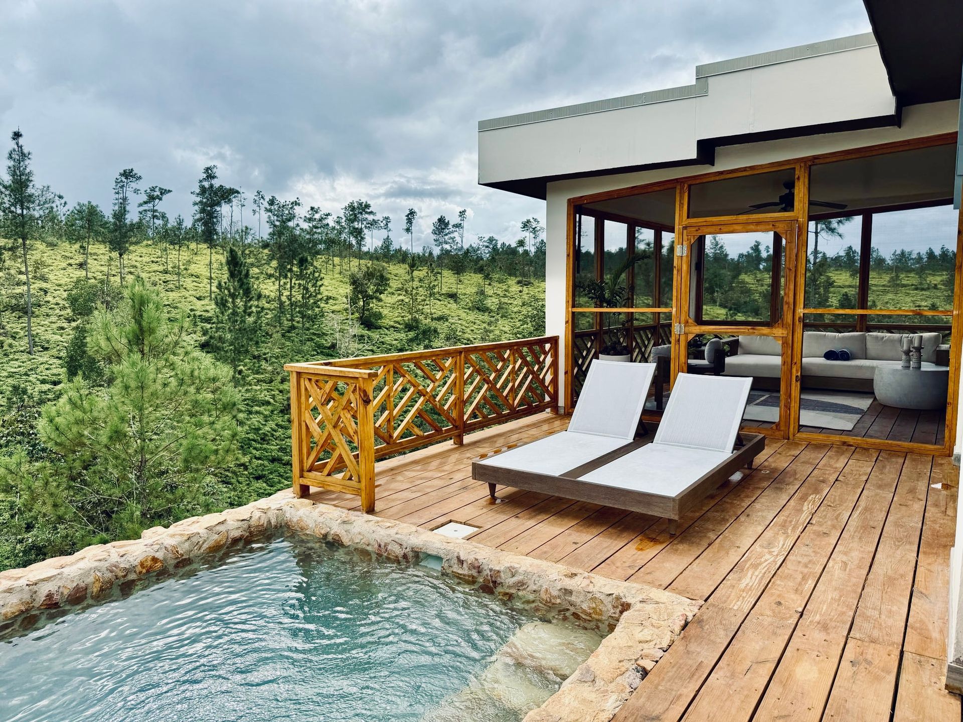 There is a swimming pool on the deck of a house.
