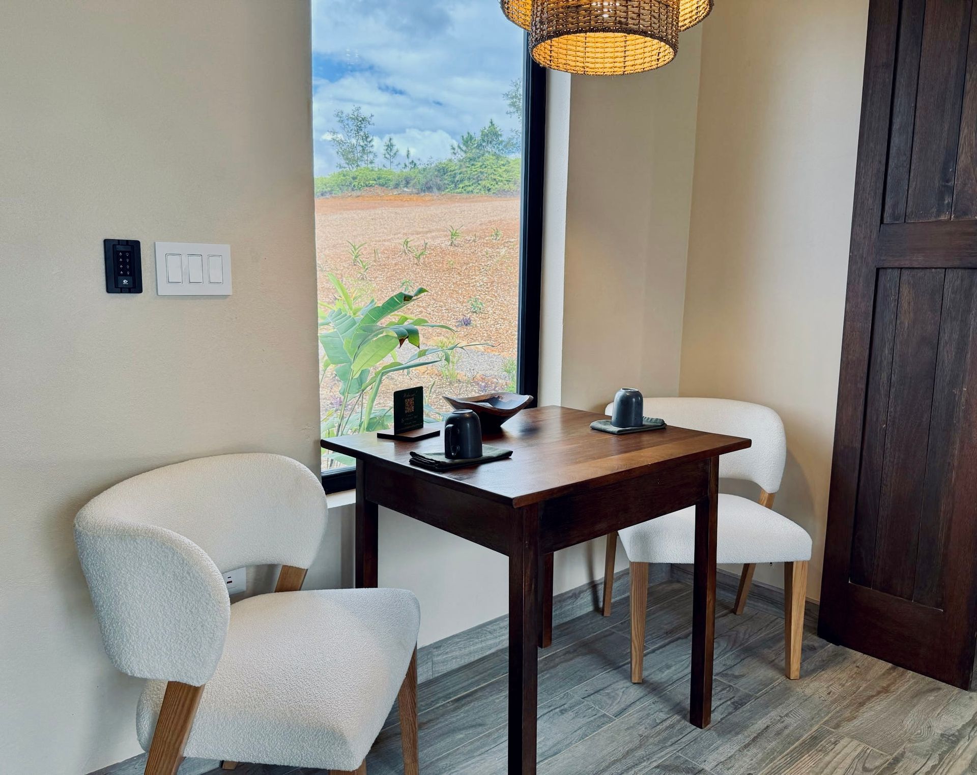 A small table with two chairs in a room next to a window.