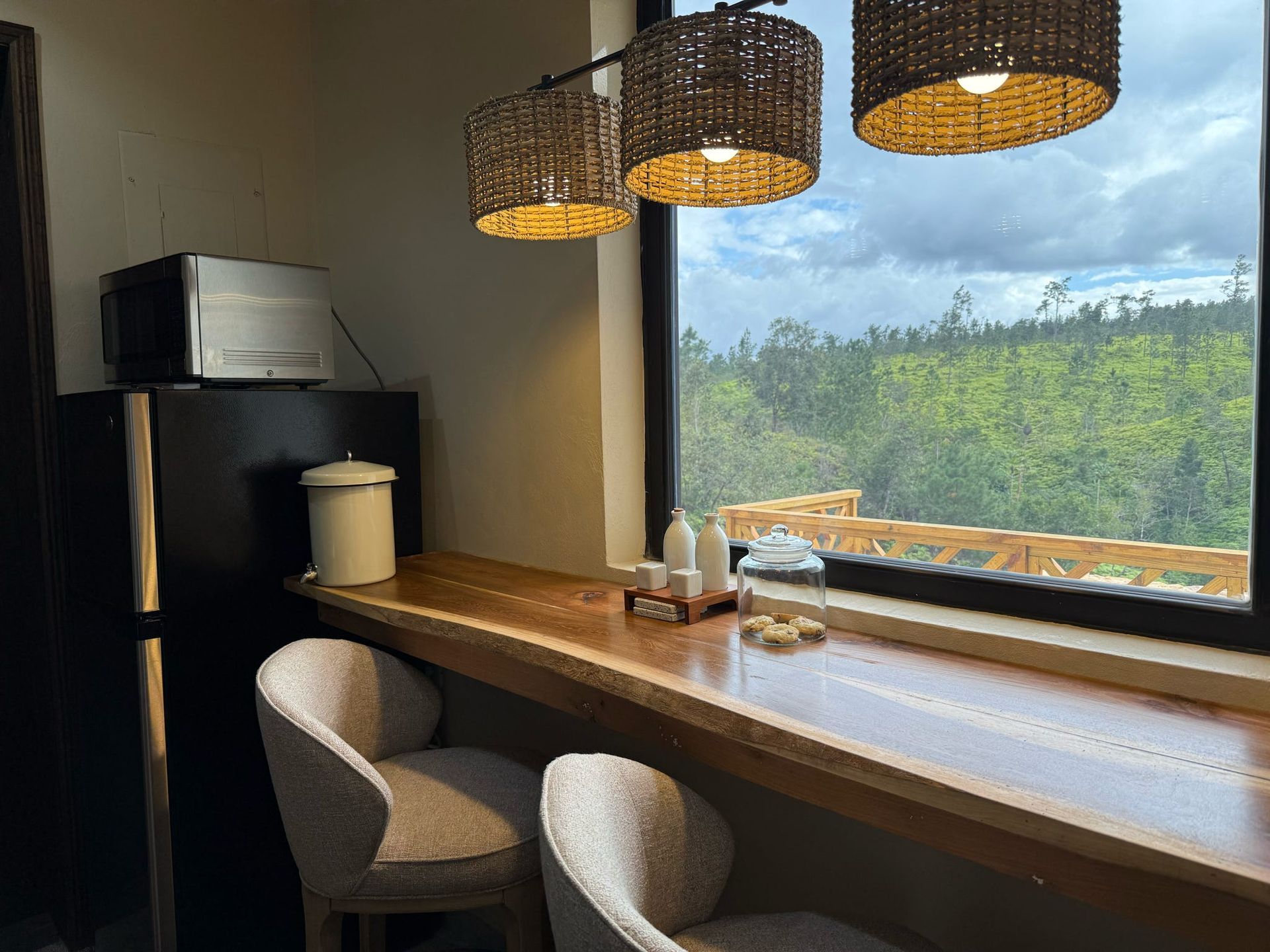 A kitchen with a long wooden table and chairs next to a window.