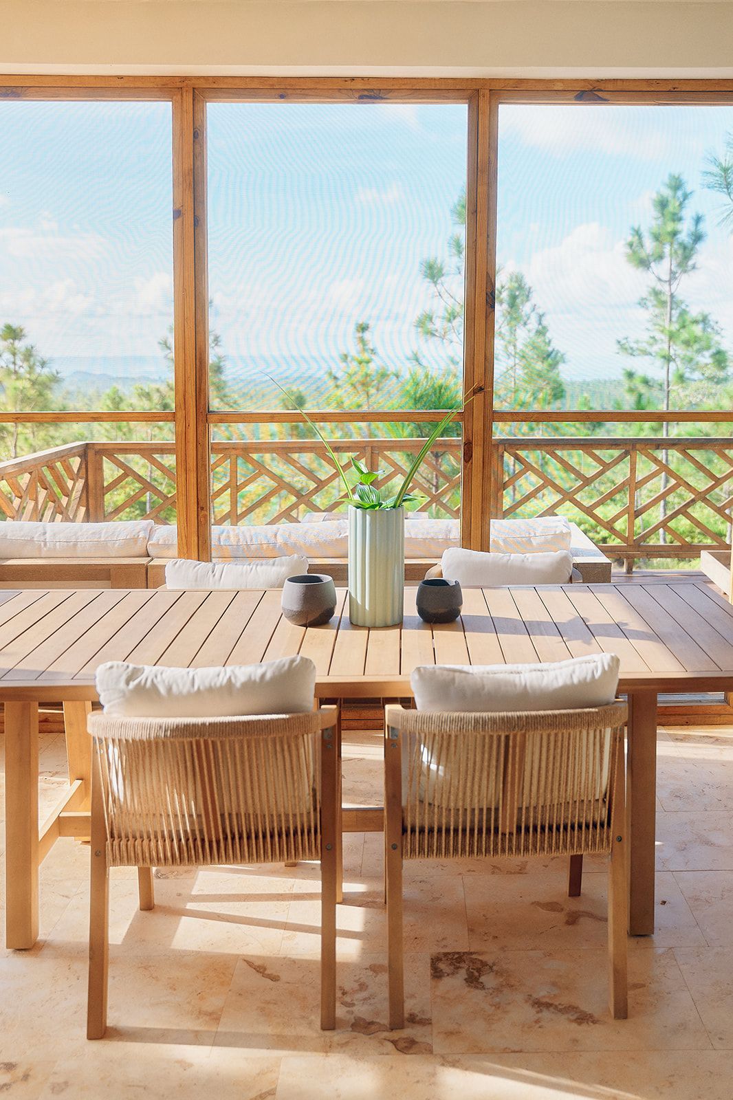 Wooden outdoor dining set with a view of trees and sky.