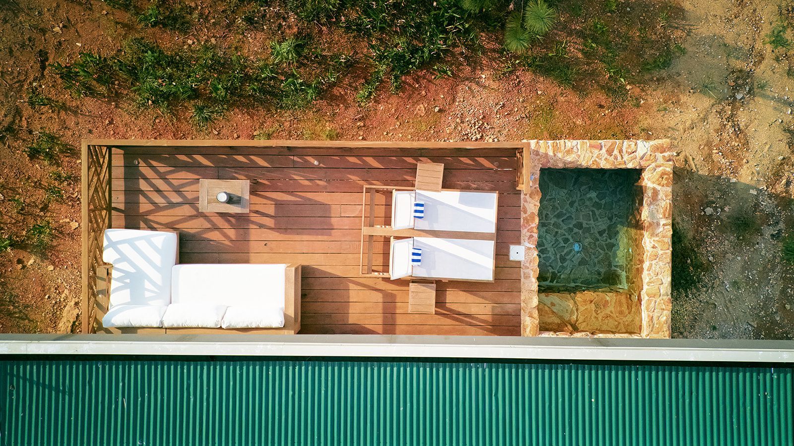 Overhead view: outdoor seating area with lounge, table, small pool, and surrounding junlge.