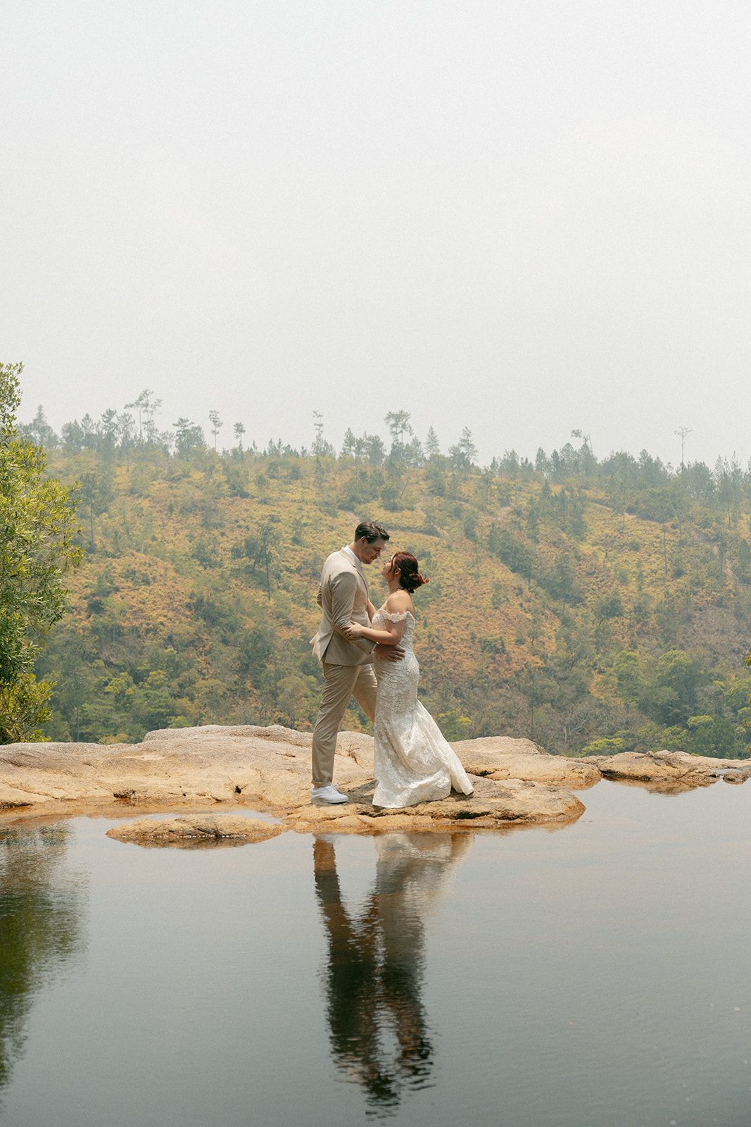 A bride and groom hold hands and smile at each other, surrounded by the breathtaking natural beauty of Hidden Valley